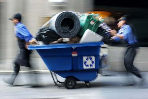 Workers sorting recyclable office materials into labelled bins